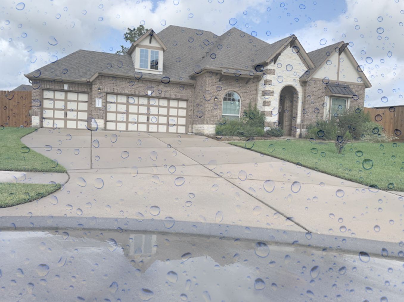 Freshly cleaned concrete driveway in front of a two-storey brick home in the Spring, TX area